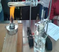 Un mechero de laboratorio calentando un tubo de ensayo con muestra de girasol