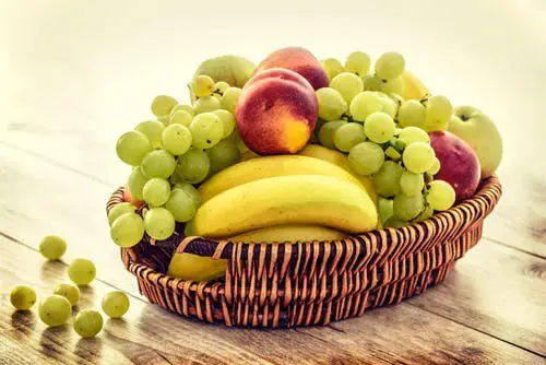 cesta de frutas con racimos de uvas verdes