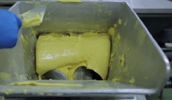 mantequilla saliendo de un contenedor de acero inoxidable 