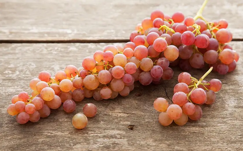 Un ramillete de uvas de color rosado anaranjado