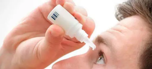 hombre colocándose colirio a base de extracto de ojos de tilapia 