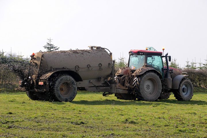tractor con tanque dispersando abono liquido a terreno
